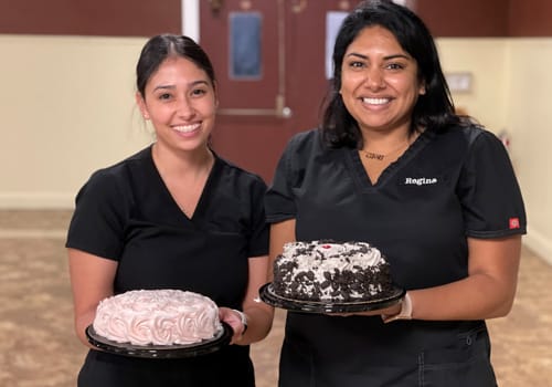 Women holding birthday cakes