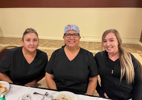 Three women smiling at a dinner event