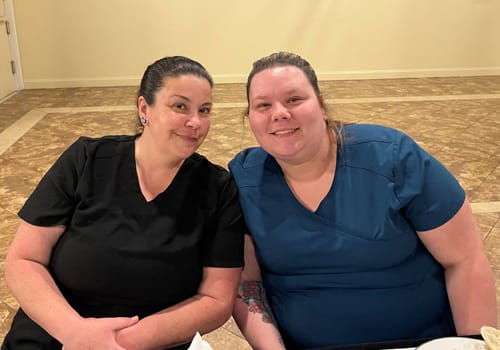 Two women smiling at a dinner event