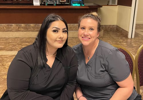 Two women smiling at a dinner event