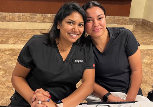 Two women smiling at a dinner event