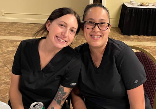 Two women smiling at a dinner event